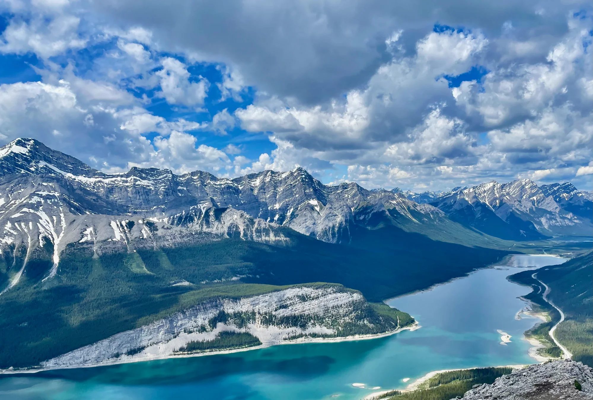 Aerial view of a glacial lake and snow-capped peaks in the Canadian Rockies